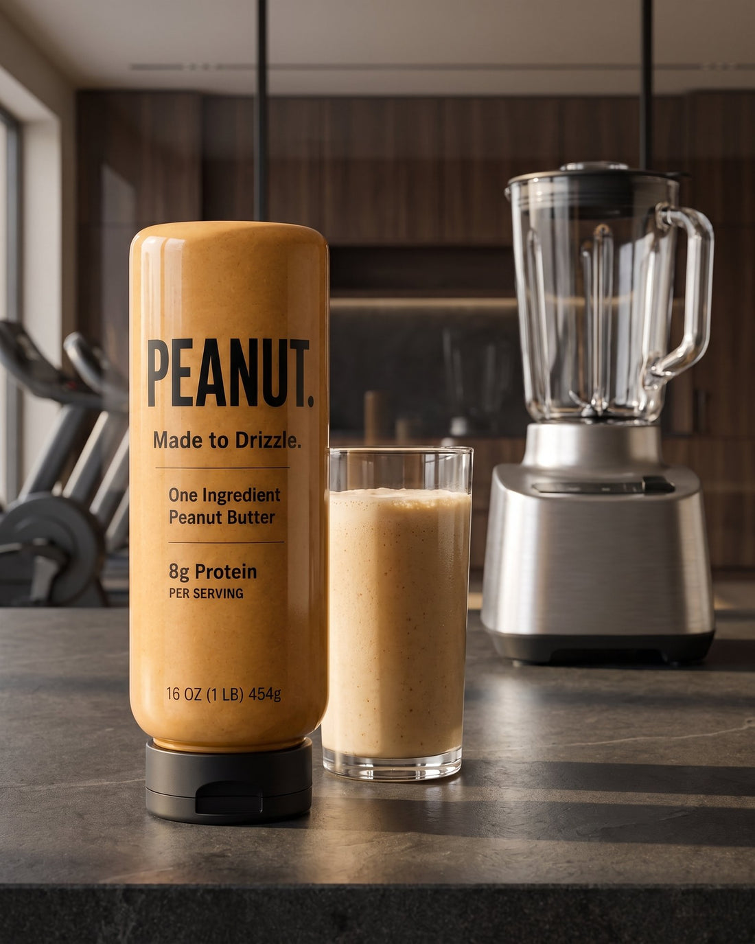 The bottle beside a peanut butter smoothie and a blender on a dark kitchen counter